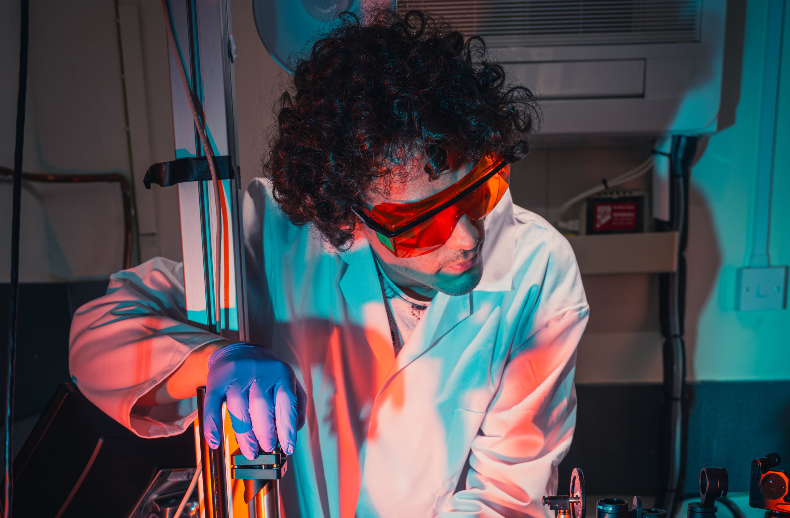 A researcher in a Physics laboratory uses high-tech laser-light equipment